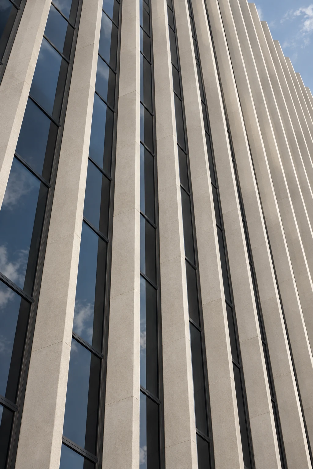 A close upward view of slender pale facade fins separated by blue-gray window strips.