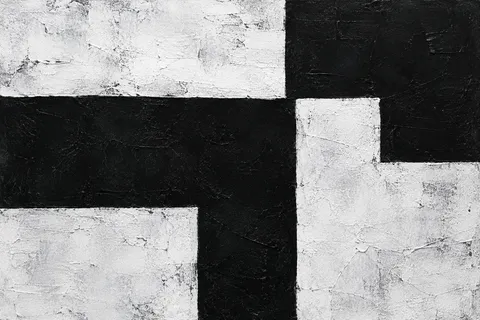 Textured interlocking black and white geometric blocks with right-angle edges.